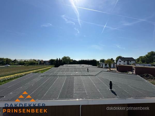 Groot plat dak met bitumen dakbedekking op bedrijfspand in Prinsenbeek Groot plat dak met bitumen dakbedekking op bedrijfspand in Prinsenbeek